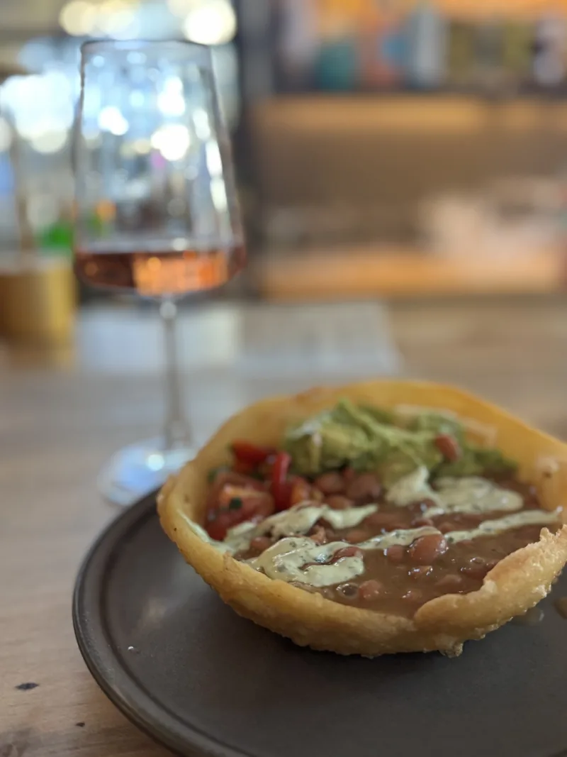 A deep fried arepa with beans, guacamole and pico