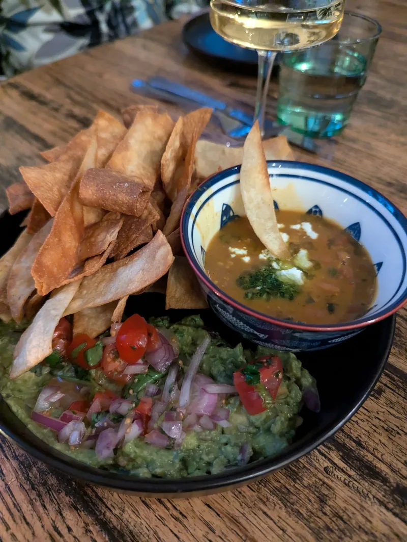 Guacamole and house-made tortilla strips with a glass of white wine