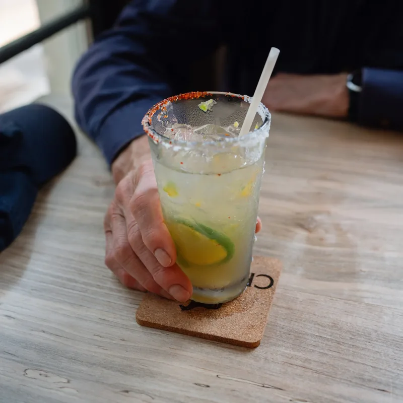 A salt-rimmed cocktail with lime and cucumber
